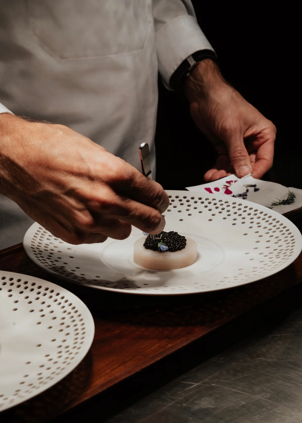 Chef plating a course of the tasting menu at Aska, one of the best luxury restaurants in Brooklyn