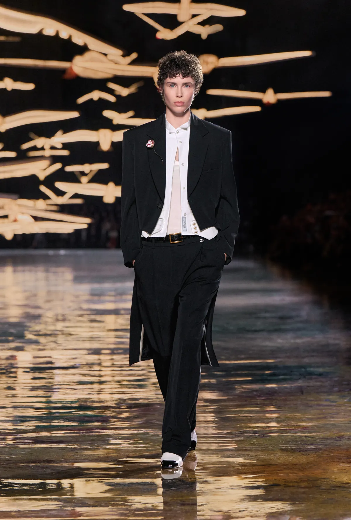 A black cutaway tailcoat over an open pleated dress shirt and wide trousers at Chanel Spring Summer 2027