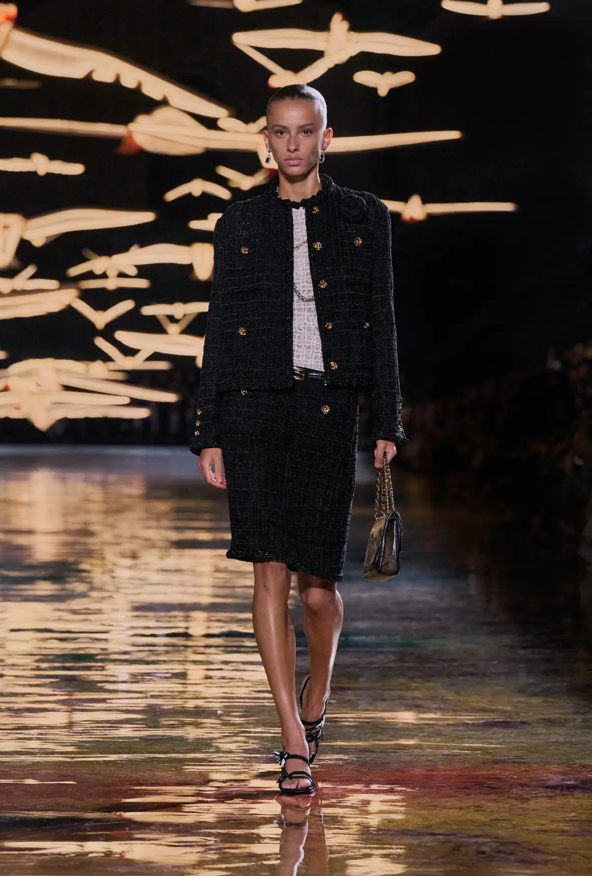 Dyanira Hurbuscher closes Chanel Spring Summer 2027 in a black tweed skirt suit carrying Gabrielle Chanel’s own 2.55 bag