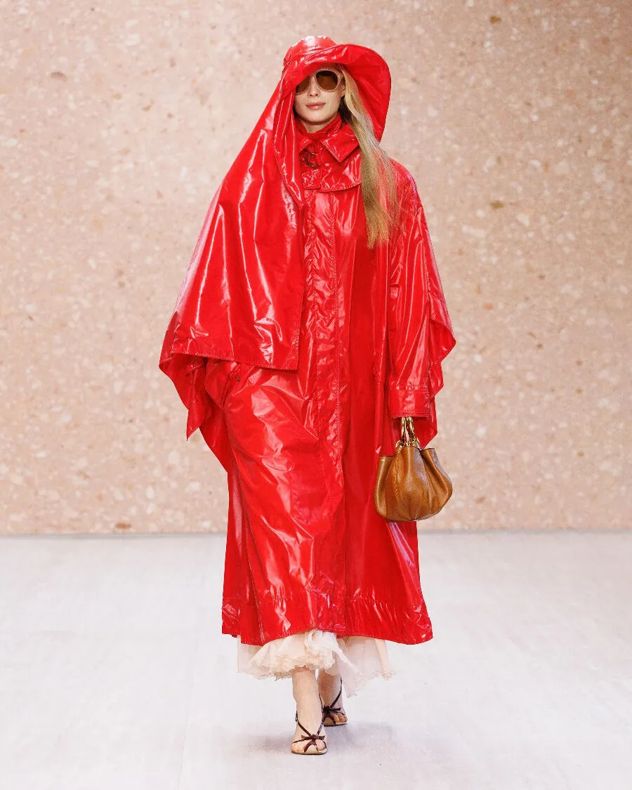 Chloé Summer 2027 Look 32, a tomato-red vinyl raincoat and matching hat, at Paris Fashion Week