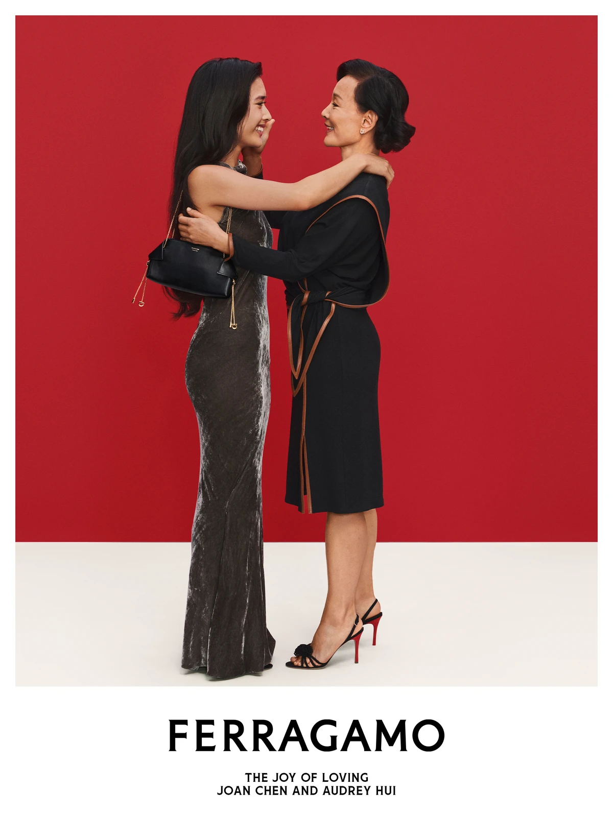 Joan Chen embracing her daughter Audrey Hui, who carries a black Ferragamo bag, in the Ferragamo holiday campaign