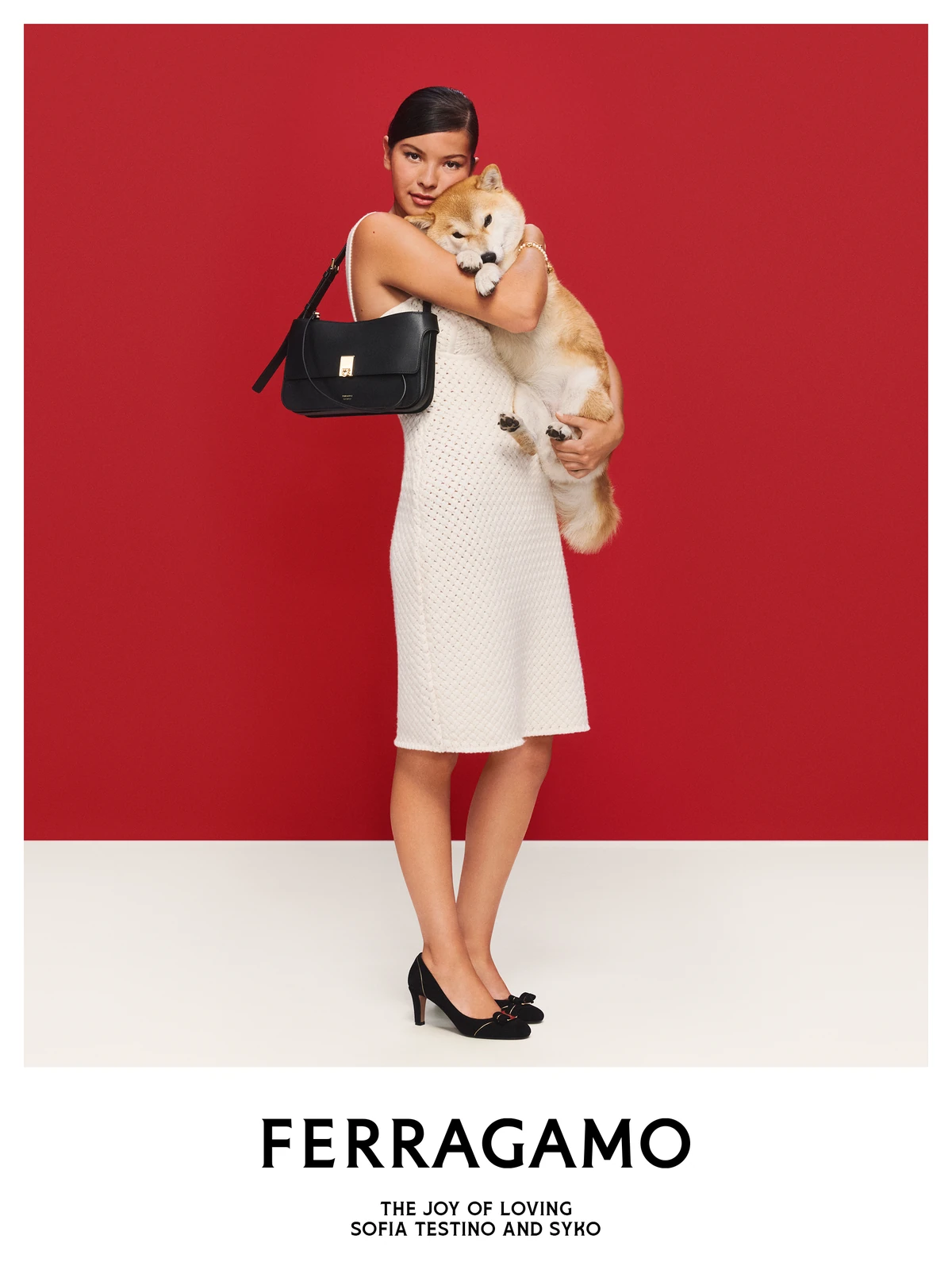Sofia Testino in a white dress holding her dog Syko and a black Ferragamo bag in the Ferragamo holiday campaign