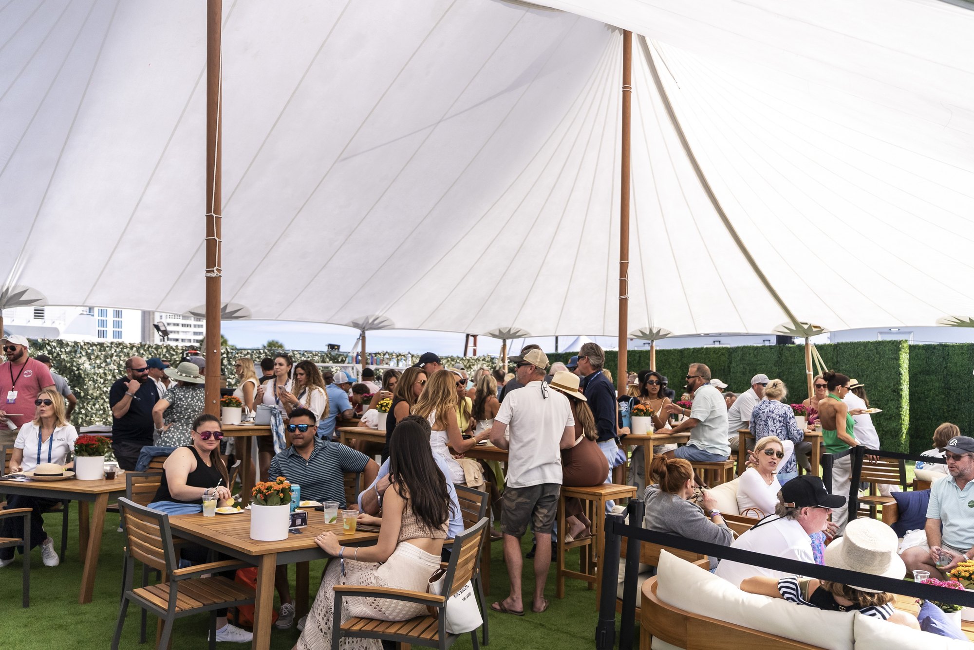 Guests dining under the sailcloth tent of the Windward VIP Cabana Club at FLIBS
