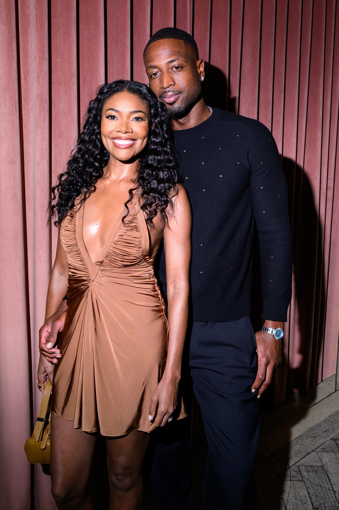 Gabrielle Union in a bronze dress and Dwyane Wade in black at the REVOLVE dinner in Miami