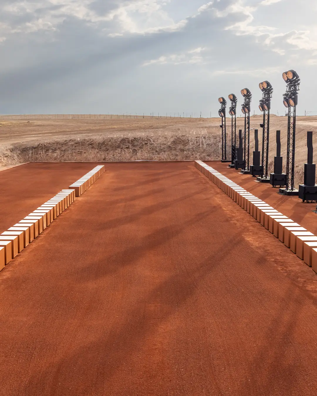 The empty Giorgio Armani & Kith Dreams of the Dune runway, a red-earth strip lined with lights in the Agafay Desert