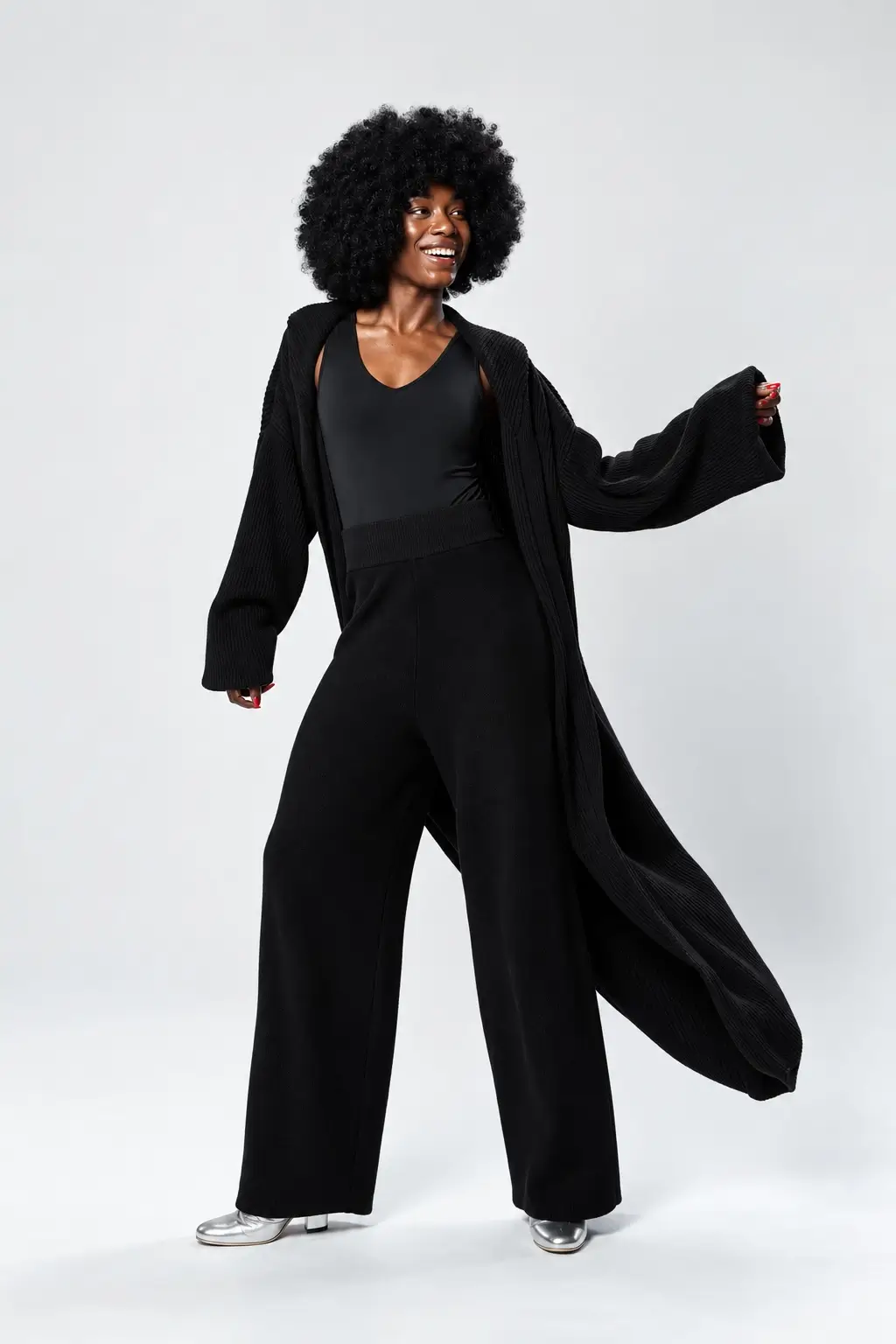 The model is wearing The Bon Voyage Bodysuit underneath, created with a crisscross compression back, this piece gently encourages better posture while offering sculpting support that moves with you throughout the day. Layered over the bodysuit is The California Knit Long Duster, this heavy knit duster is designed to envelop you in cozy comfort with a relaxed fit. Along with the NY Knit Pant, these knit pants blend urban style with ultimate comfort, designed for those who are always on the move.