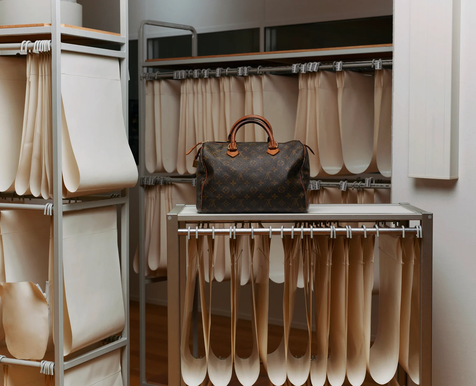 Louis Vuitton Care & Repair: bags awaiting restoration on workshop shelves