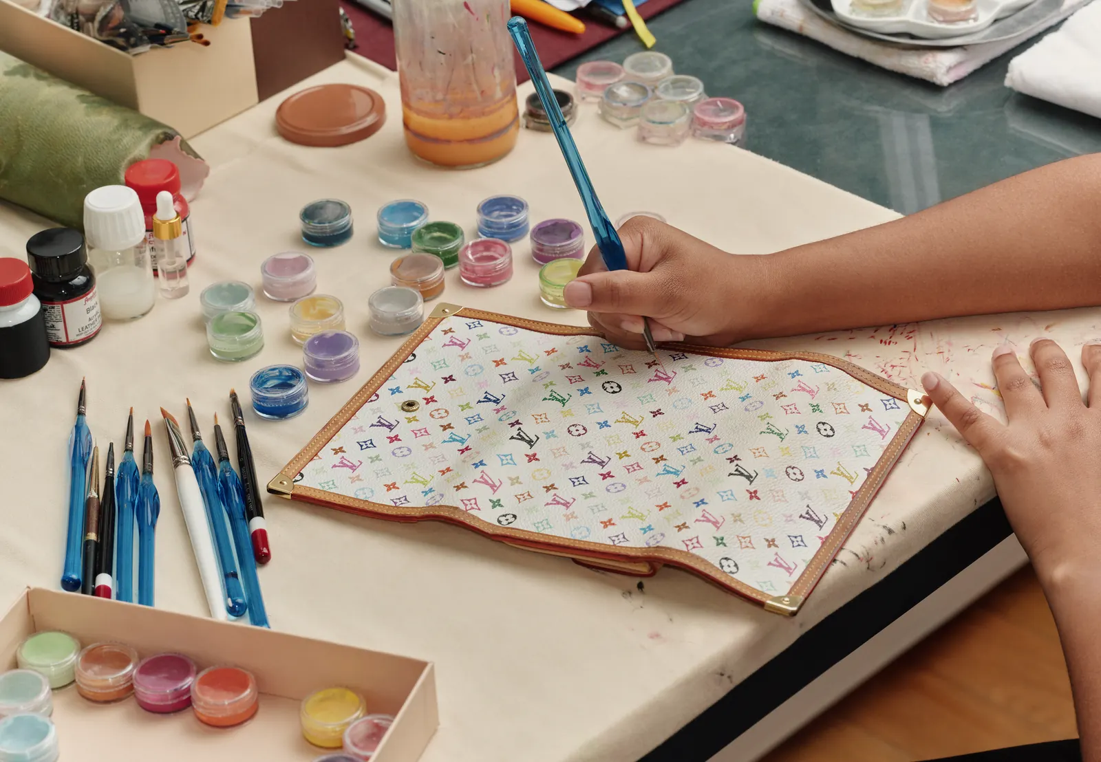 Louis Vuitton Care & Repair: artisan hand-painting a colorful Monogram canvas