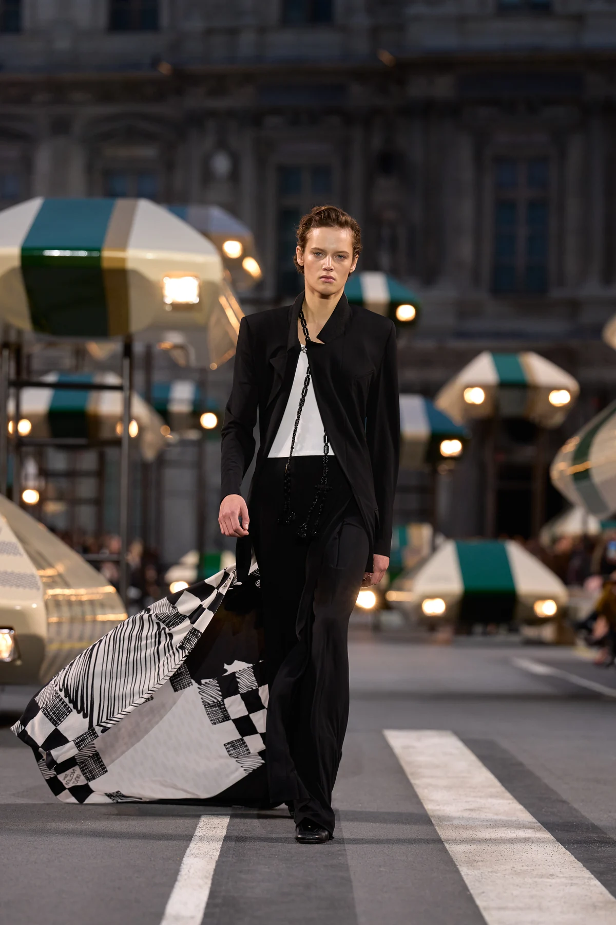 The Louis Vuitton Spring Summer 2027 finale, look 48, a black pantsuit trailing a black and white checked carre scarf