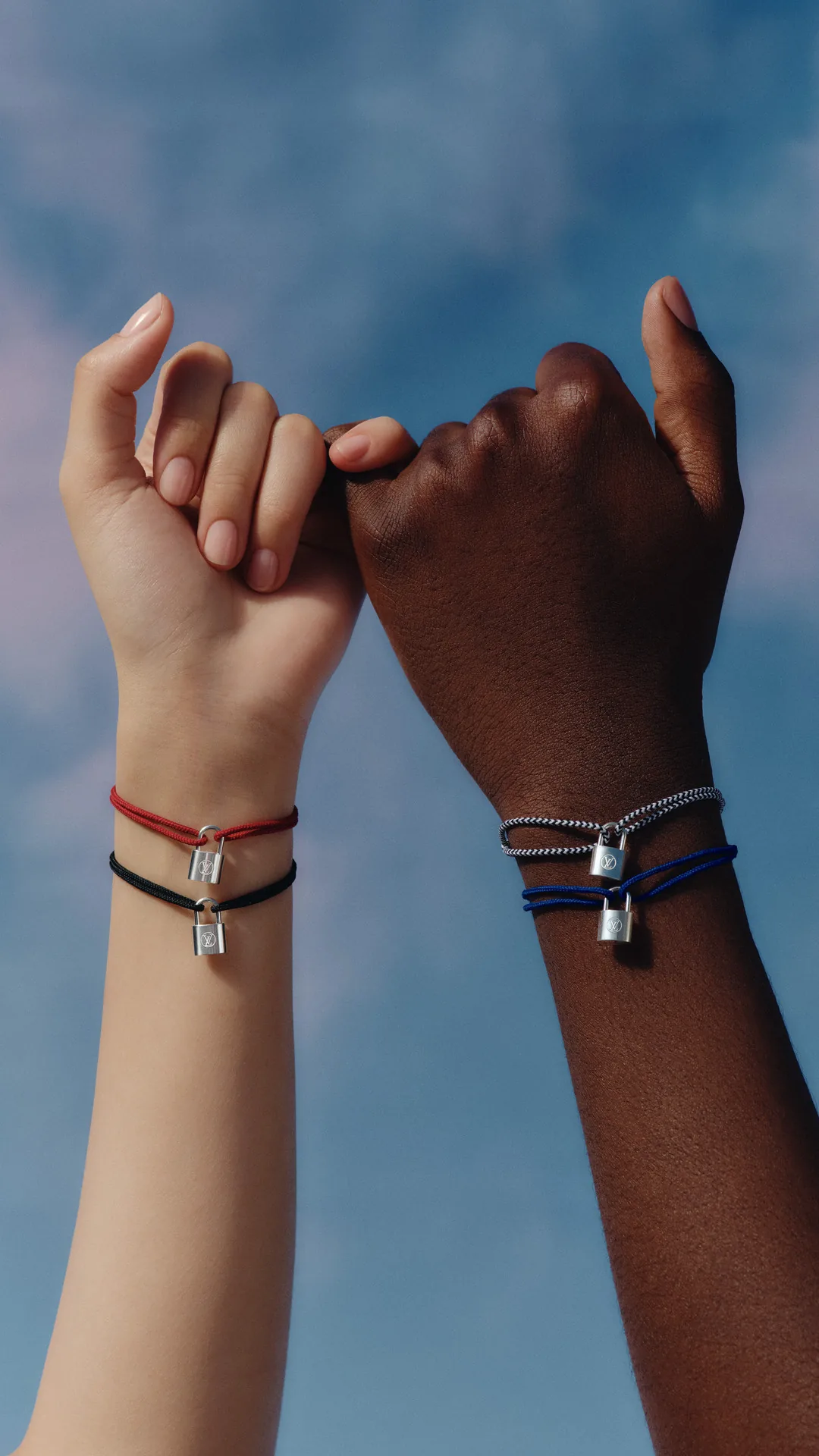 Louis Vuitton for UNICEF: Silver Lockit bracelets worn on linked hands
