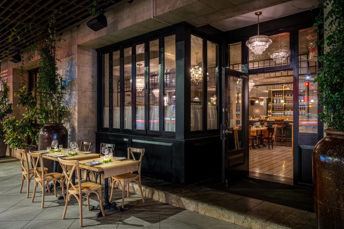 Chandeliers and patio tables at Malka Beverly Hills at SIXTY Beverly Hills, one of the best new restaurants in Los Angeles