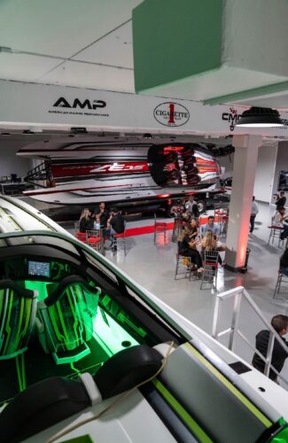 Overhead view of the Outerlimits Fort Lauderdale dealership showroom during the reception, with guests around cocktail tables and the SC37 and SC46 catamarans on display