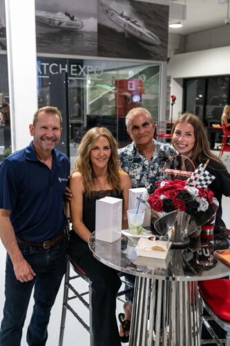 Guests mingling at a cocktail table at the Outerlimits Powerboats reception in Fort Lauderdale