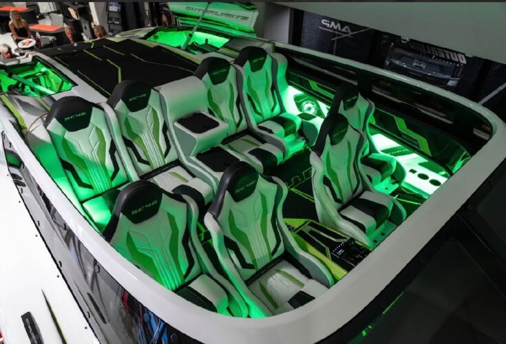 Green-lit cockpit of the Outerlimits SC46 catamaran, with SC46-embroidered bucket seats, on display at the Fort Lauderdale dealership
