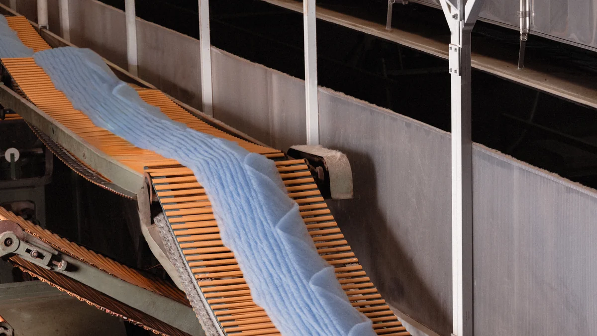 Recycled fiber moving through a carding machine during Prada Re-Wool production