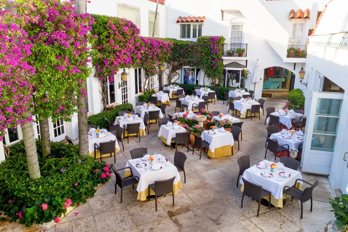 Bougainvillea-framed courtyard tables at Renato’s in Via Mizner, a romantic date night restaurant in Palm Beach