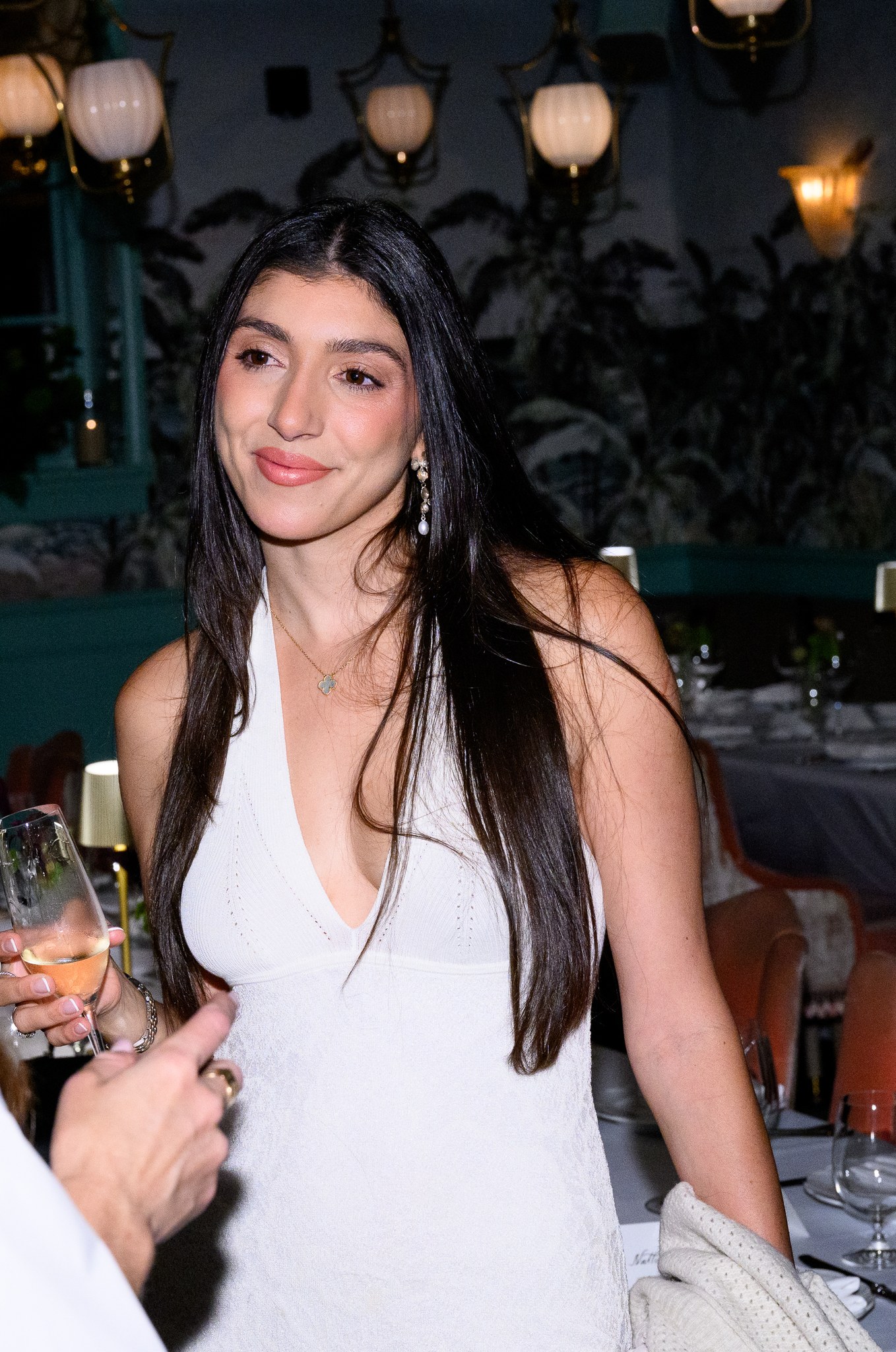 Rupi Kaur in a white dress at the REVOLVE dinner at Casadonna in Miami