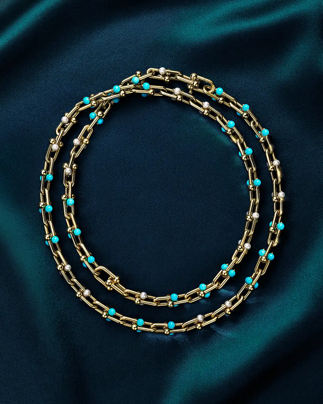 Tiffany HardWear necklace in 18k yellow gold with turquoise beads and Akoya pearls coiled on dark teal satin